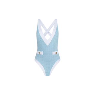 The Lisa Plunge One-Piece Swimsuit, shown on a plain white background, is crafted from bouclé swim fabric in powder blue with white trim. It features crisscross straps, a deep V neckline, and two decorative white tabs with gold buttons at the waist.