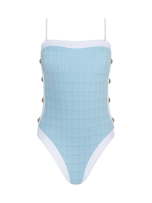 The Tory Bandeau One-Piece Swimsuit is powder blue with thin white straps, white trim, side buttons, and a textured bouclé pattern. High-cut legs give this swimsuit a chic, modern look.