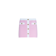The Coco Mini Skirt Cover-Up is a pink and white bouclé mini skirt featuring gold buttons down the front and two decorative pockets, showcased against a plain white background.