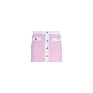 The Coco Mini Skirt Cover-Up is a pink and white bouclé mini skirt featuring gold buttons down the front and two decorative pockets, showcased against a plain white background.