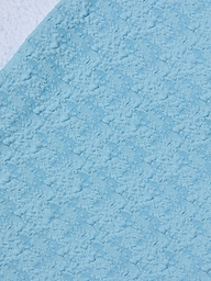 Close-up of the Vanessa High-Waisted Bikini Bottom in light blue bouclé swim fabric, featuring a raised, patterned surface with diagonal lines and soft, fluffy patches throughout.