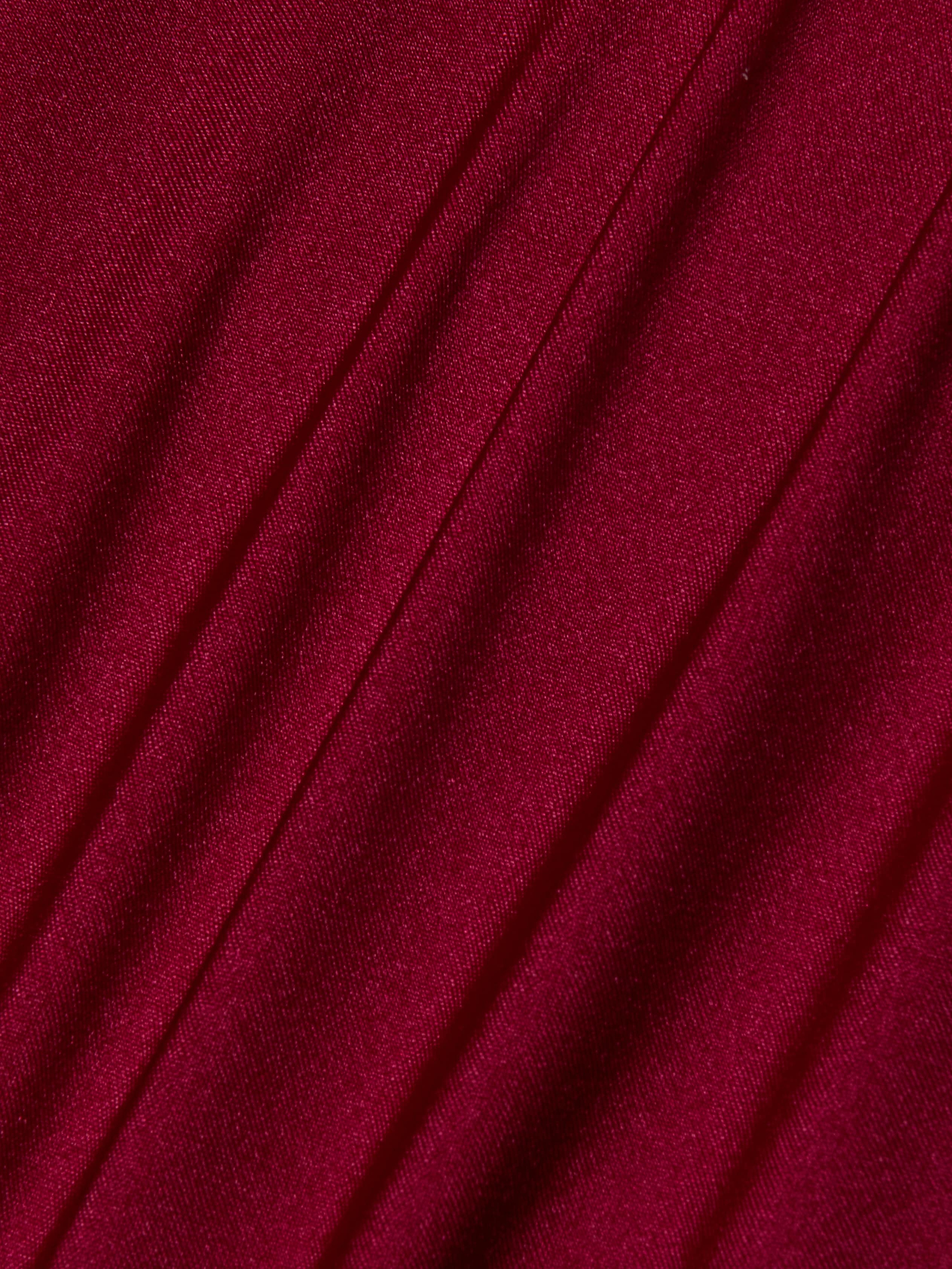 Close-up of Nicole Bikini Bottom in deep red, black cherry fabric with diagonal folds and a smooth, slightly shiny texture. The soft material and gentle shadows add depth—making it an essential swimwear piece.
