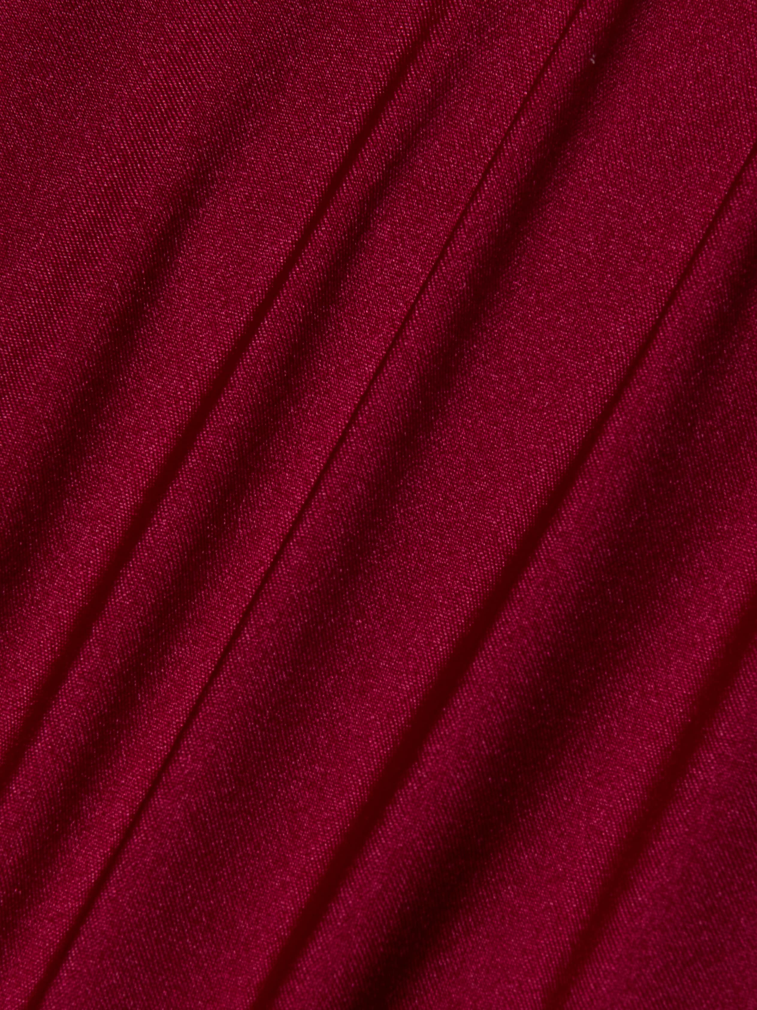 Close-up of Nicole Bikini Bottom in deep red, black cherry fabric with diagonal folds and a smooth, slightly shiny texture. The soft material and gentle shadows add depth—making it an essential swimwear piece.