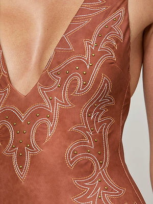 The Lisa Plunge One-Piece Swimsuit by L'AGENCE Sale showcases a brown suede-look finish, deep plunge neckline, intricate white stitching, and small gold studs in decorative patterns.