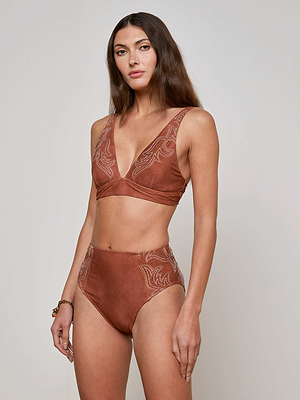 A woman with long brown hair wears the L'AGENCE Sale Lexie Bikini Top, styled with high-waisted bottoms featuring Western-inspired embroidery. She poses against a plain light background, looking at the camera with a neutral expression.