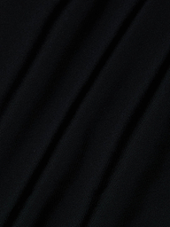 Close-up of black fabric from the Shiva One-Piece Swimsuit, featuring diagonal folds and a smooth, slightly shiny texture.