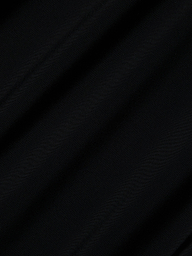 Close-up of the Akola One-Piece Swimsuit’s black UPF 50 fabric, featuring diagonal, subtle folds and a soft, lightly textured surface. The lighting casts gentle shadows that enhance the swimsuit’s smooth look.