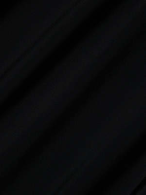 Close-up of the Akola One-Piece Swimsuit’s black UPF 50 fabric, featuring diagonal, subtle folds and a soft, lightly textured surface. The lighting casts gentle shadows that enhance the swimsuit’s smooth look.