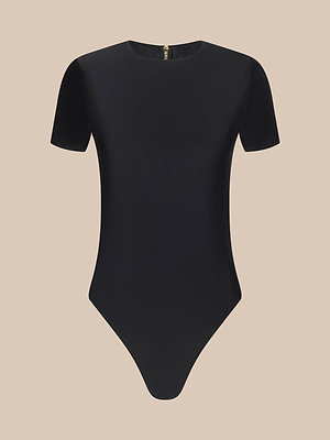 The Akola One-Piece Swimsuit is a black short-sleeve bodysuit with a crew neckline, high-leg cut, and back zipper, shown on a plain beige background.