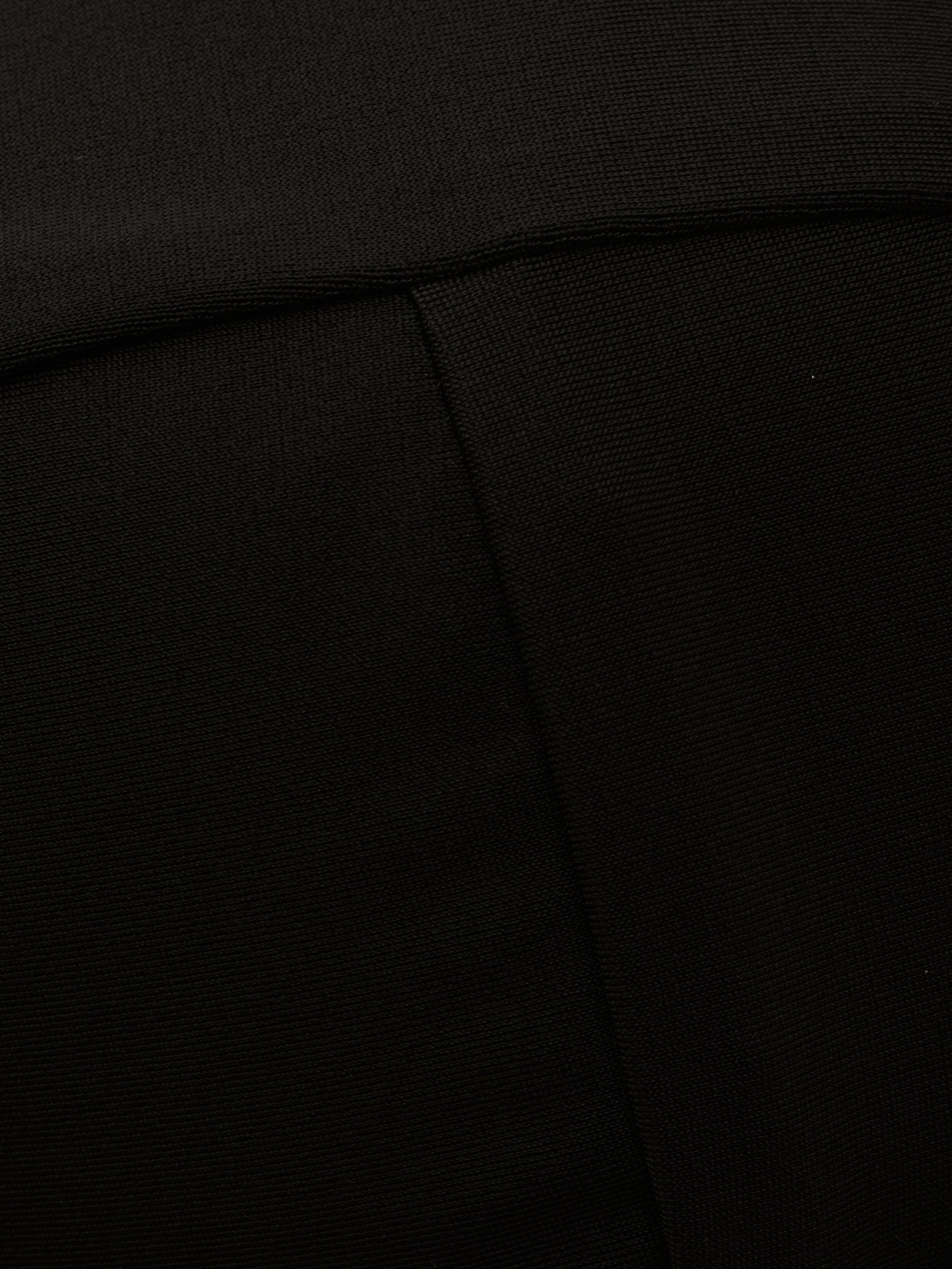 Close-up of the Alexandria Bikini Top in black, showcasing its textured fabric with a visible diagonal seam and a fold near the top of the image.