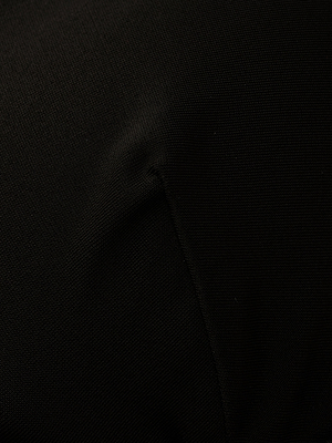 Close-up of black fabric with a prominent diagonal seam and subtle texture, reminiscent of trapunto stitching, featured on the Adrienne Bikini Top.