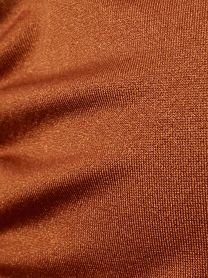 Close-up of a rust-colored, textured fabric with subtle horizontal ribbing and gentle folds, reminiscent of the Annabelle Triangle Bikini Top featuring luxe hardware for an elevated, adjustable fit.