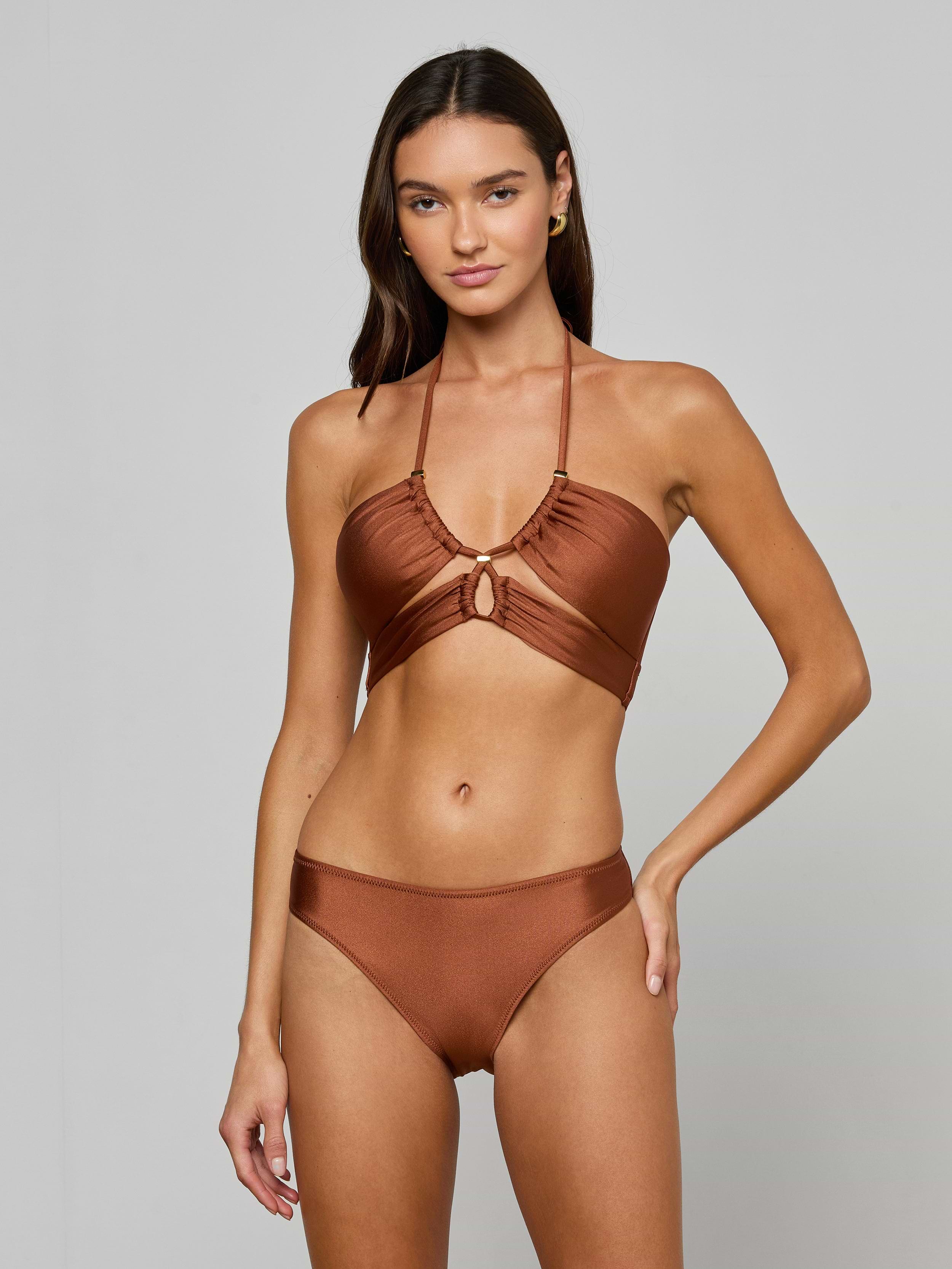 A woman with long brown hair wears the Sirena Halter Bikini Top with matching bottoms, standing against a plain light gray background.