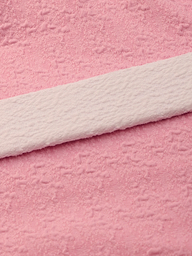 Close-up of soft pink bouclé nylon fabric with a subtle textured pattern and a white textured strip laid across it diagonally, similar to the luxurious materials used in the Amie Bandeau One-Piece Swimsuit.