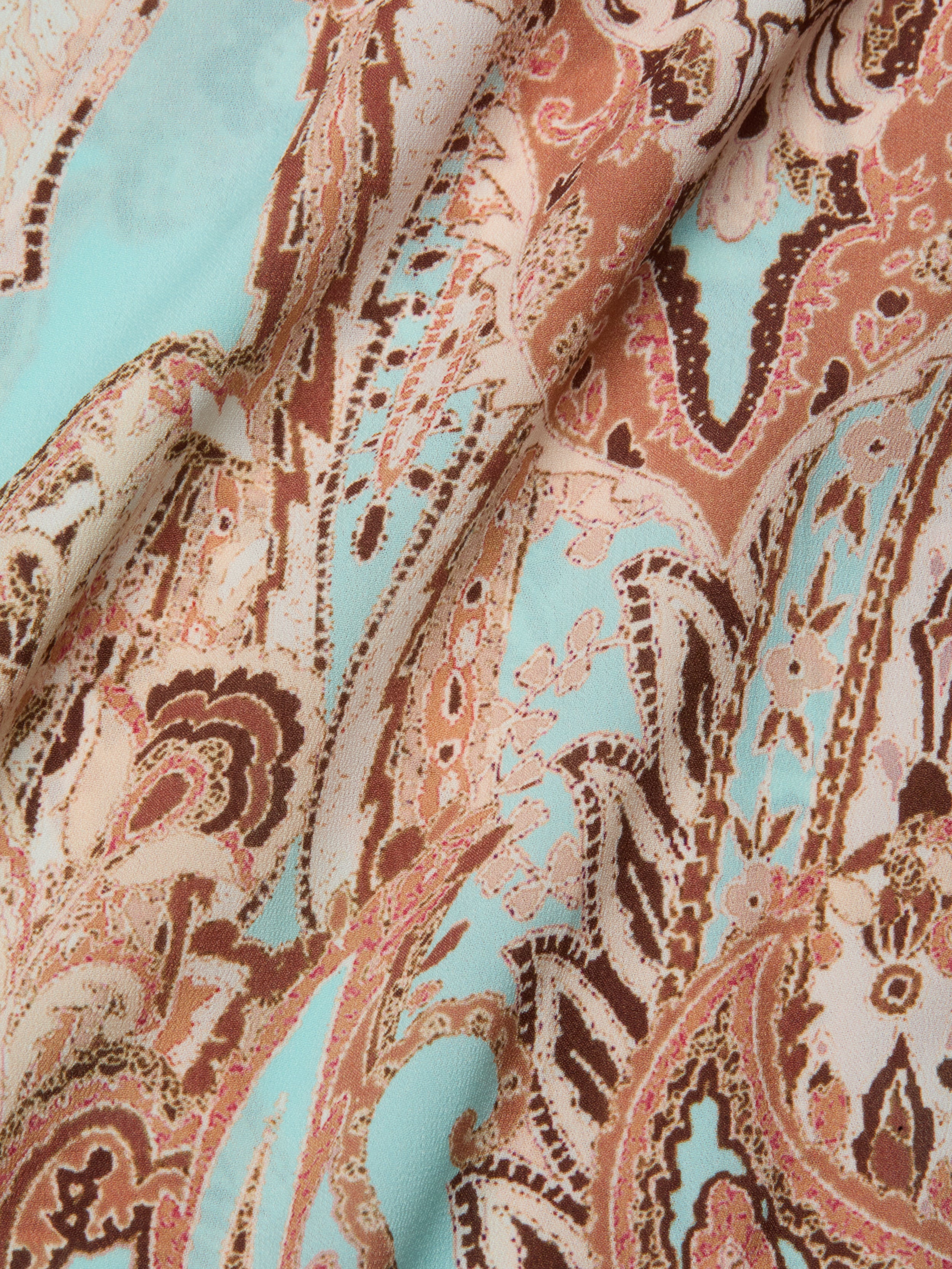 A close-up of the Elise Cover-Up Dress, crafted from water-safe crepe fabric with an intricate paisley print in shades of brown, pink, and turquoise, featuring flowing shapes and detailed floral designs.