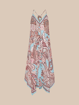 The Elise Cover-Up Dress is a sleeveless, V-neck handkerchief dress with spaghetti straps, featuring a light blue and pink paisley print and an asymmetric hem in water-safe crepe, shown on a beige background.
