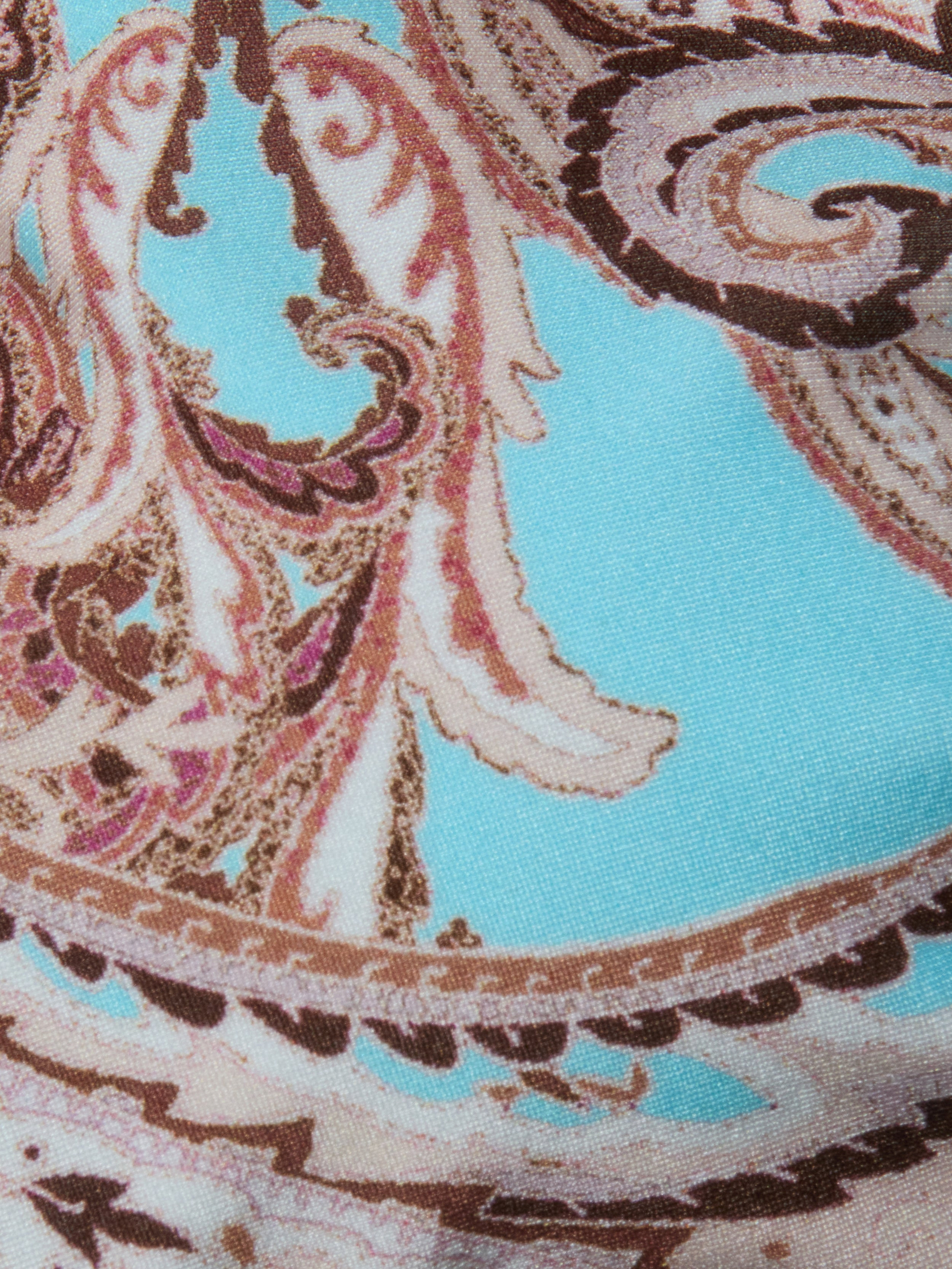 Close-up of the Alisha Bikini Top fabric, featuring an ornate paisley pattern in brown, beige, and pink set against a vibrant turquoise background. This intricately designed textile is ideal for swim separates, offering both standout style and UPF 50 sun protection.