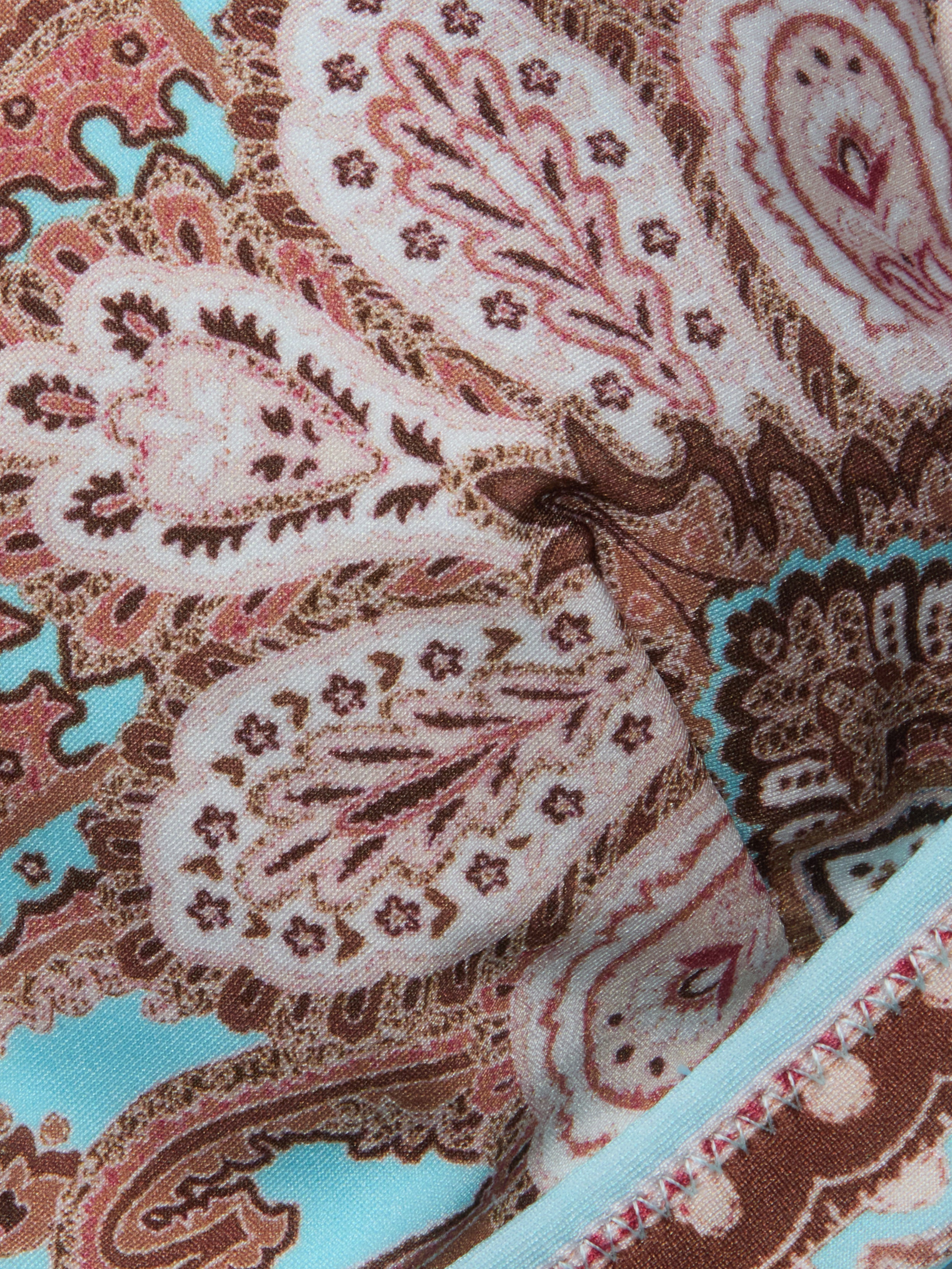 Close-up of the Lexie Bikini Top, featuring colorful fabric with an intricate paisley print in shades of pink, brown, and blue. The detailed stitching and decorative designs are highlighted, along with its adjustable straps.