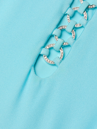 Close-up of the Indore One-Piece Swimsuit in ice blue, showcasing fabric with a cutout detail. Silver rings, linked by fabric loops, accentuate the design—some adorned with small, sparkling rhinestones.