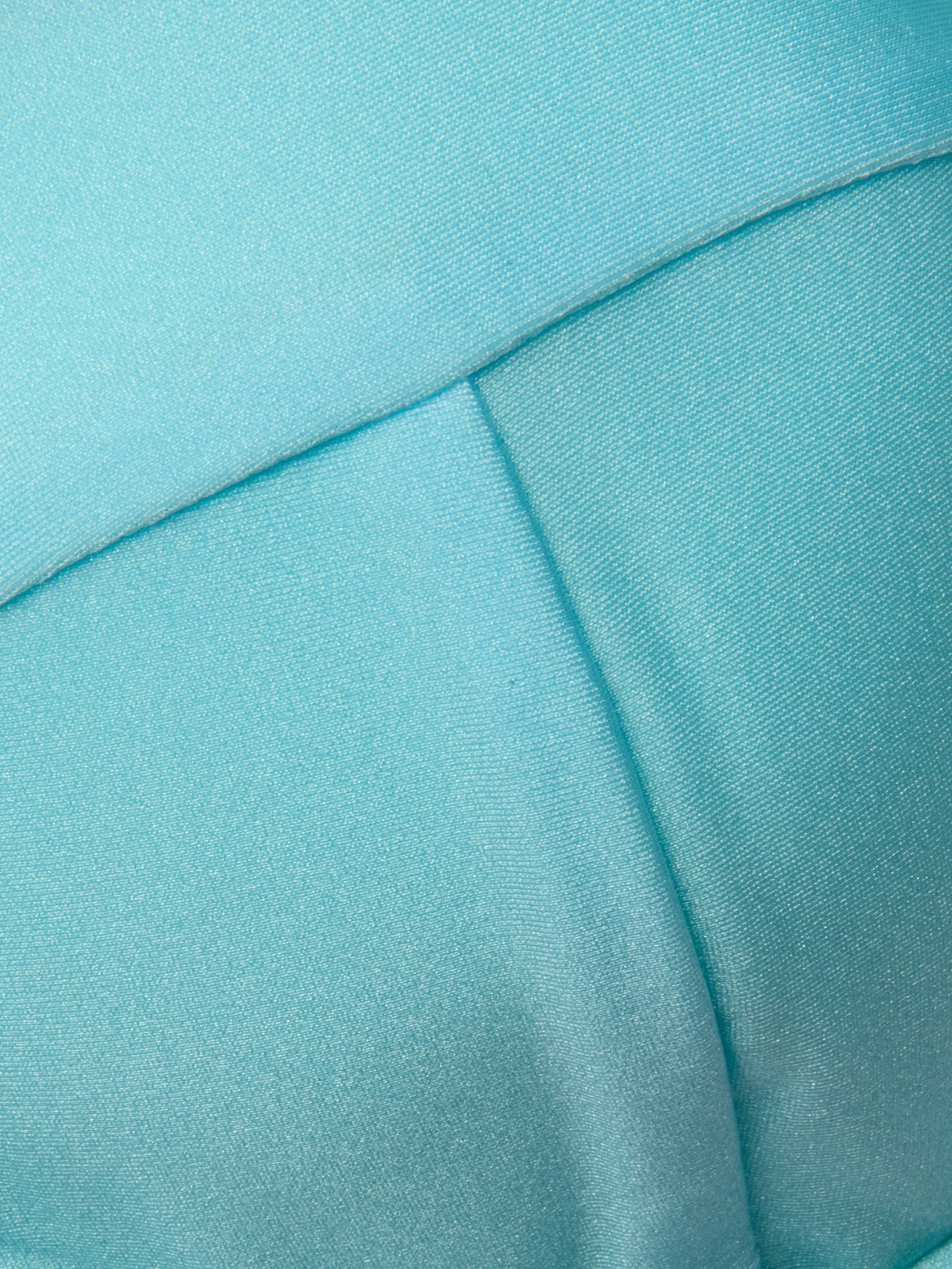 Close-up of light blue fabric with visible stitching and seams, featuring a smooth, slightly shiny texture—ideal for the Alexandria Bikini Top, expertly crafted from UPF 50 swimwear material.
