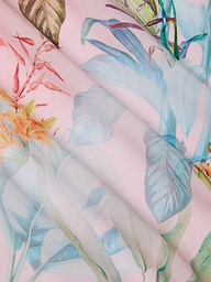 The Marena Sarong features a pastel floral fabric with a pink background and delicate blue, green, and orange leaves in a soft, watercolor pattern—perfect as a vacation sarong or beach cover-up.