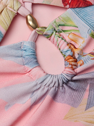 Close-up of the Siwan Midkini, showcasing colorful, patterned fabric with gathered elastic details and a gold bead, displayed on a light pink background. The midkini features soft pastel shades with a floral or abstract design.