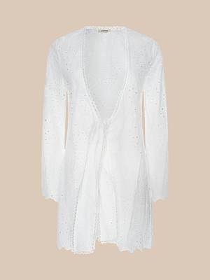 The Navaeh Cover-Up Kimono is a white, long-sleeved garment featuring delicate cotton eyelet embroidery, scalloped edges, and a waist tie, shown on a plain beige background.