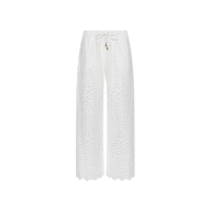 The Geraldine Eyelet Cover-Up Pant features a white, wide-leg silhouette crafted from cotton eyelet, complete with scalloped hems and a tie waist accented by small decorative charms—making it perfect for resort wear. Shown against a plain white background.