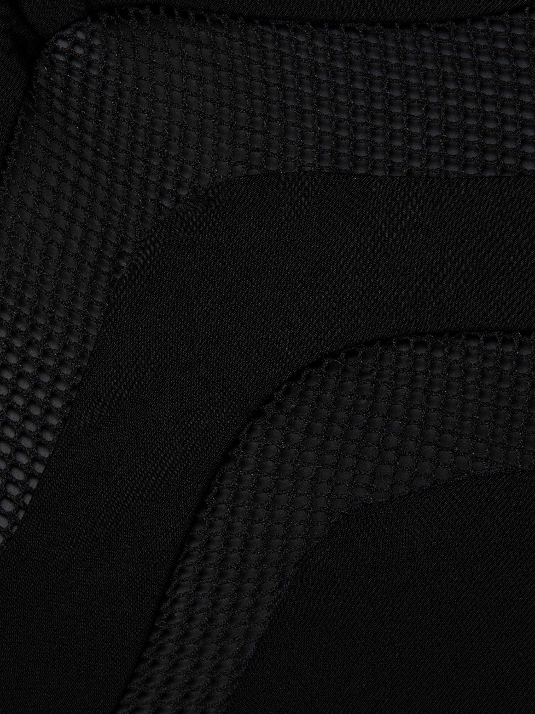 Close-up of the Gabrielle One-Piece Swimsuit in black, featuring a textured hexagonal pattern next to smooth fabric—highlighting its UPF 50 protective swimwear design.