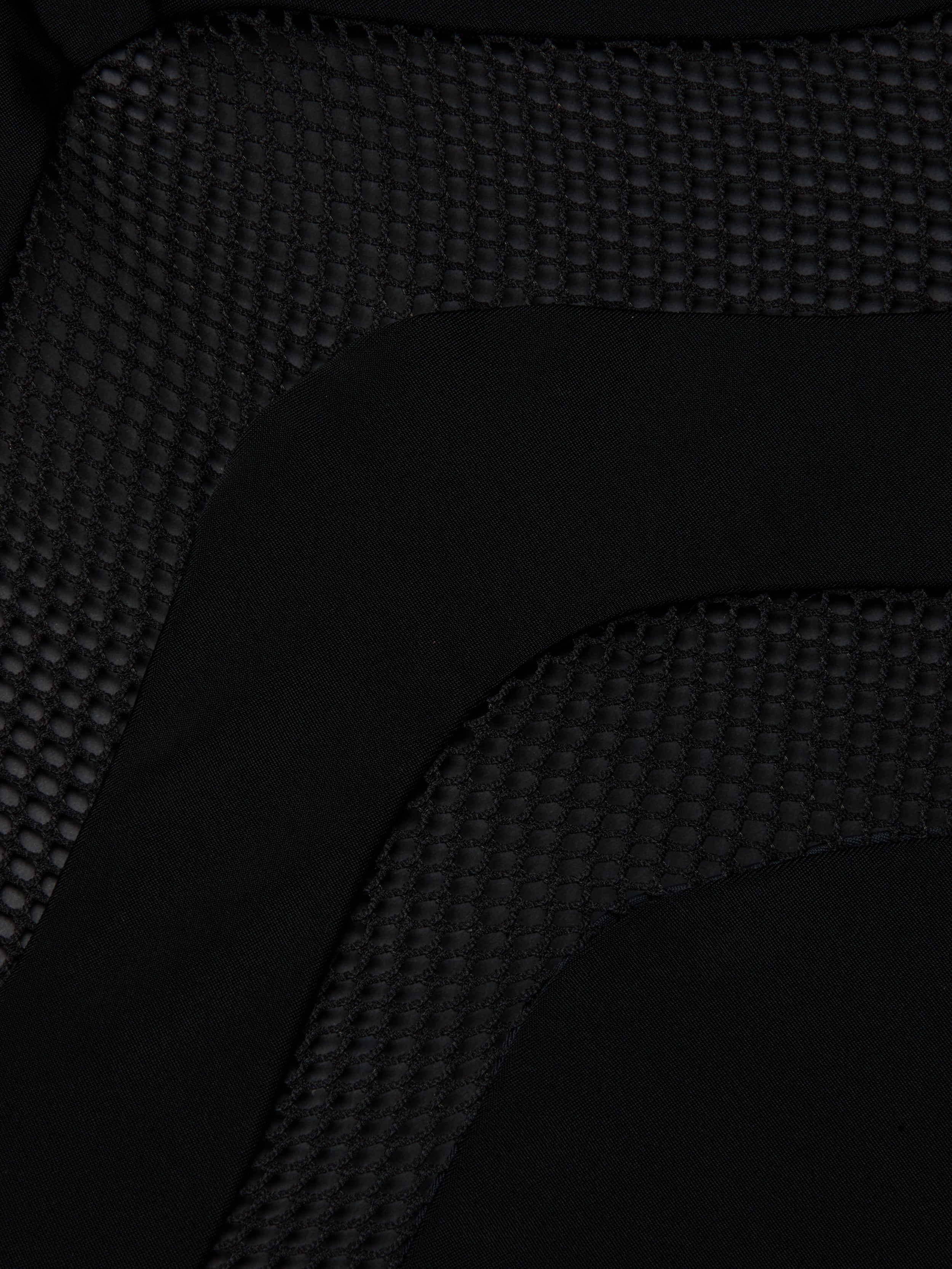 Close-up of the Gabrielle One-Piece Swimsuit in black, featuring a textured hexagonal pattern next to smooth fabric—highlighting its UPF 50 protective swimwear design.