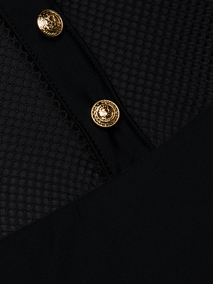 Close-up of the Natalya Collared One-Piece Swimsuit: black honeycomb-textured fabric with two shiny gold buttons, a dividing black strip, and contrasting mesh and smooth sections for a chic look.