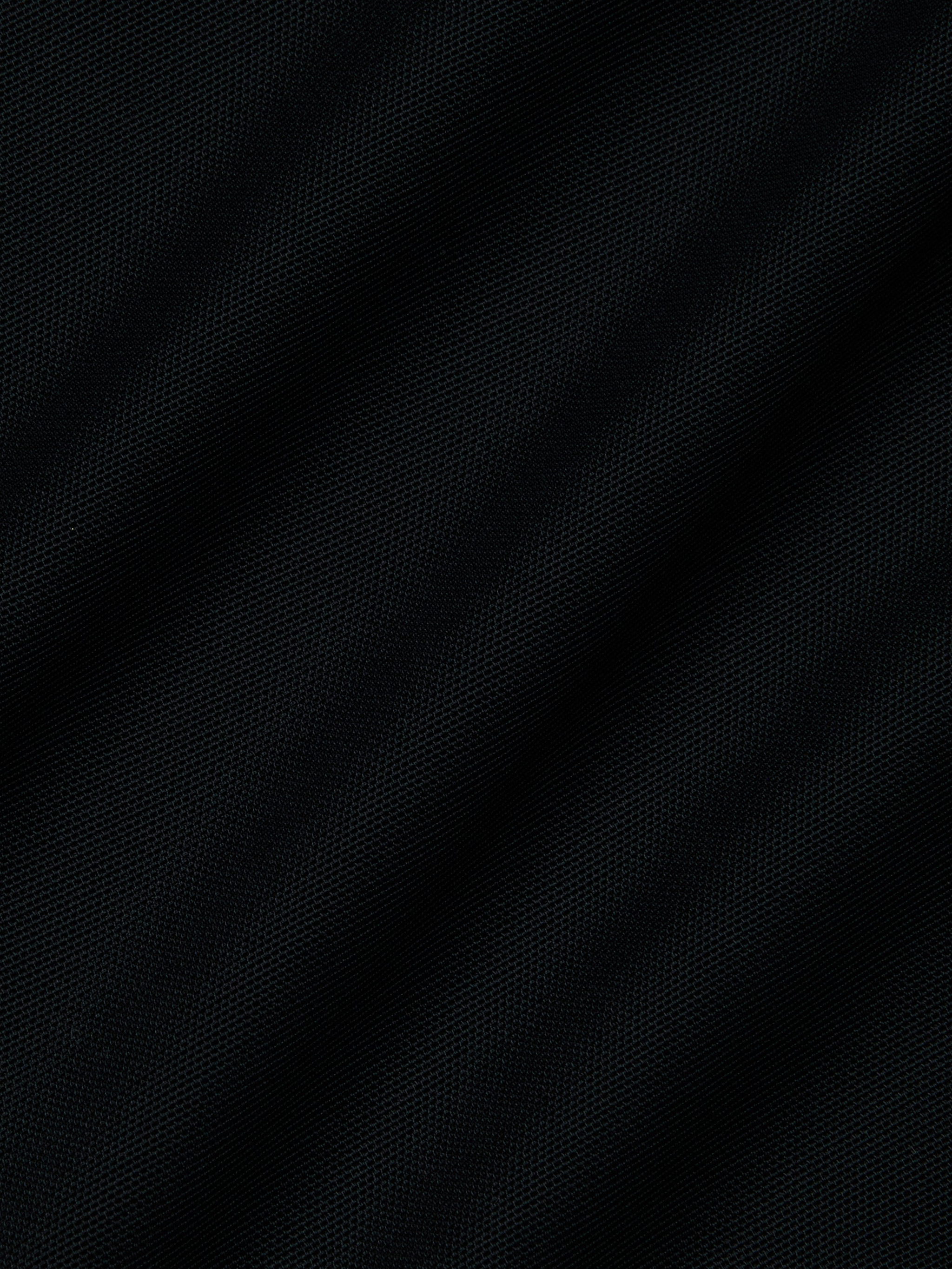 Close-up of dark black mesh fabric with a subtle diagonal weave and gentle folds—ideal for the Ambala Mesh Cover-Up Top to enhance your beachside style.