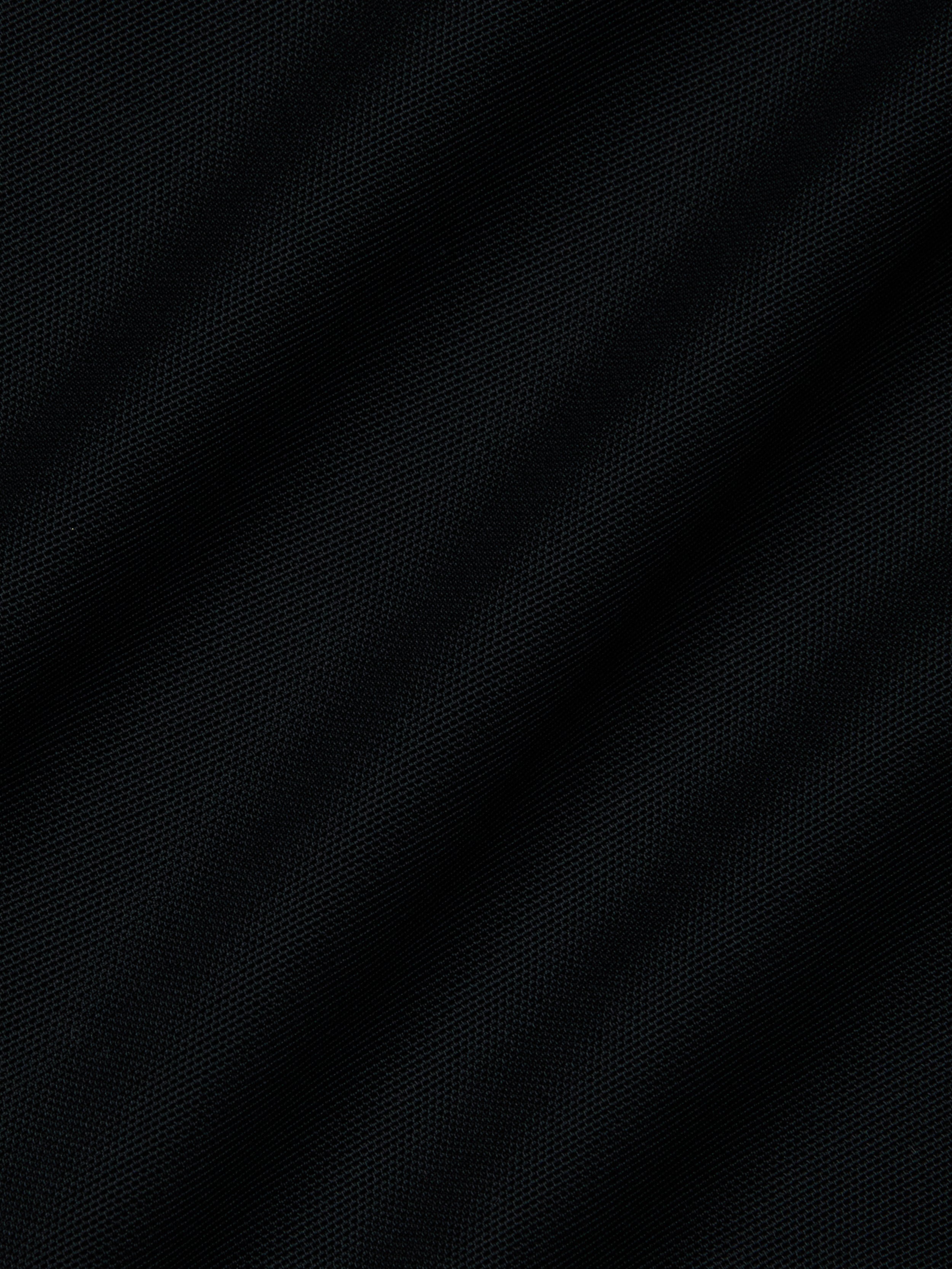 Close-up of dark black mesh fabric with a subtle diagonal weave and gentle folds—ideal for the Ambala Mesh Cover-Up Top to enhance your beachside style.