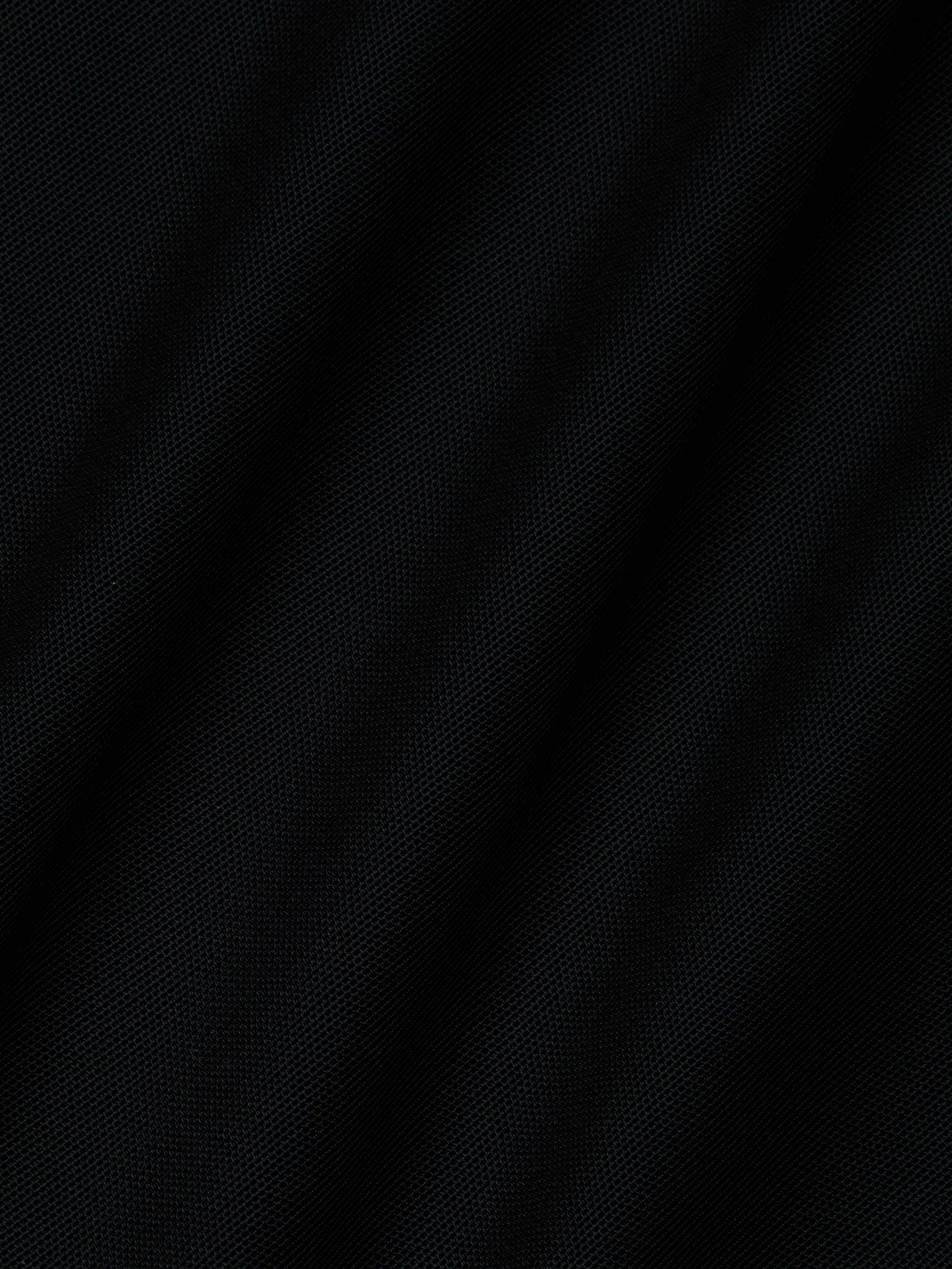 Close-up of the black Mahe Mesh Cover-Up Skirts textured fabric, featuring subtle diagonal folds that evoke a mermaid skirt—ideal for a chic poolside look.