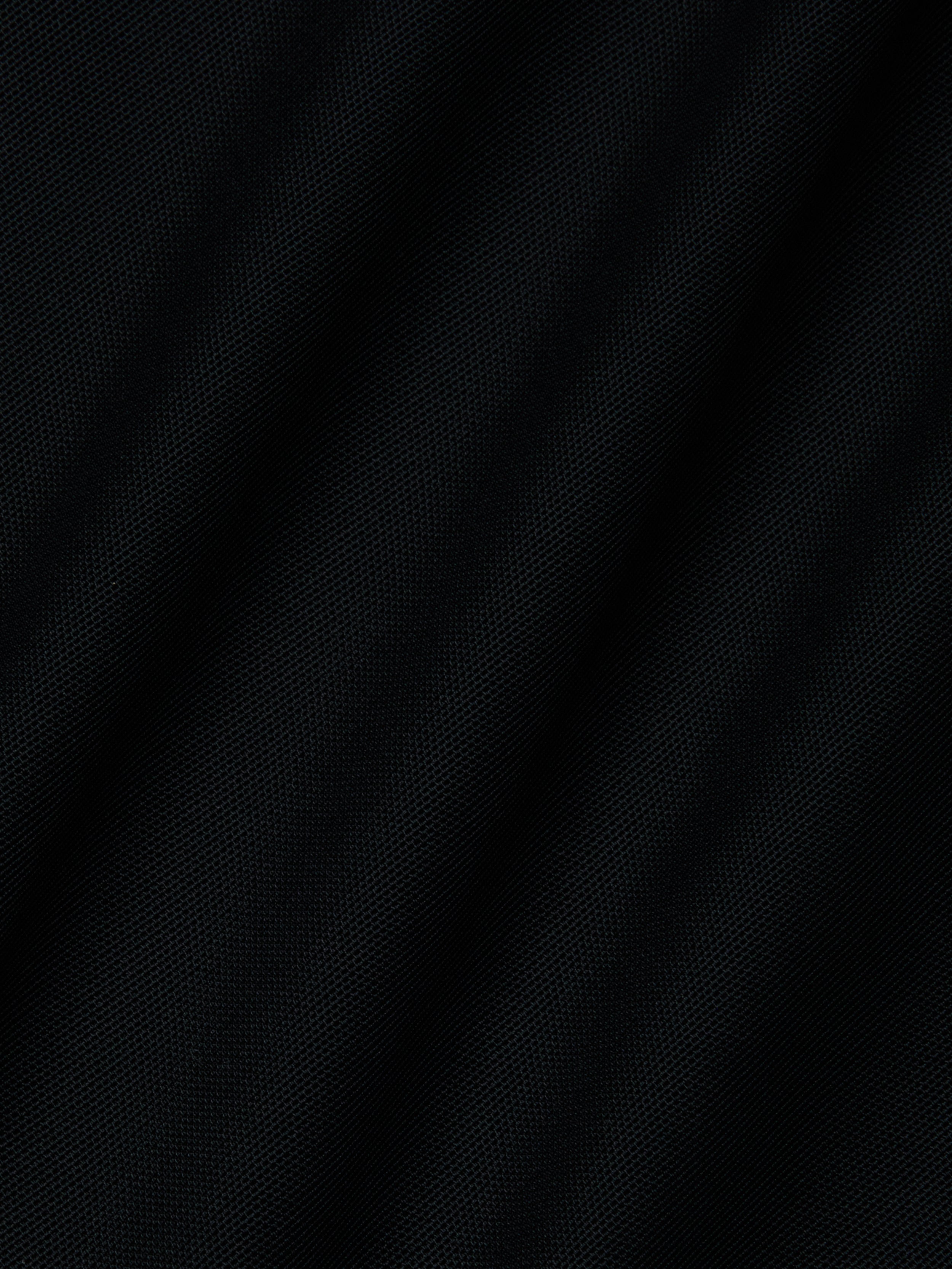 Close-up of the black Mahe Mesh Cover-Up Skirts textured fabric, featuring subtle diagonal folds that evoke a mermaid skirt—ideal for a chic poolside look.