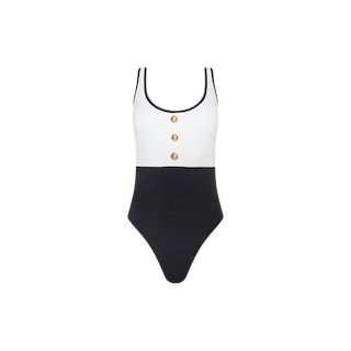 Introducing the Mila One-Piece Swimsuit: a sleeveless, two-tone design featuring a crisp white top, contrasting black bottom, thin black straps, and three gold buttons down the front. This French-inspired swimwear piece showcases a high-leg cut silhouette for an effortlessly chic and glamorous beach look.