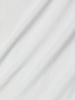 Close-up of white textured fabric with a subtle geometric pattern and soft diagonal folds—an ideal choice for the Breana Plunge One-Piece Swimsuit.