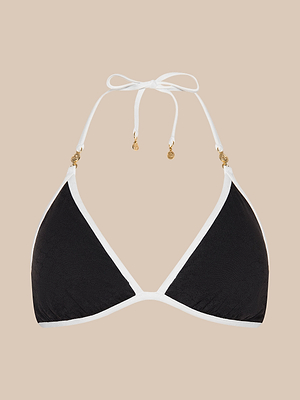 The Annabelle Bikini Top is a black triangle bikini with white trim, halter neck ties, and gold accents on the strings. This adjustable swimsuit offers style and comfort, shown against a beige background.