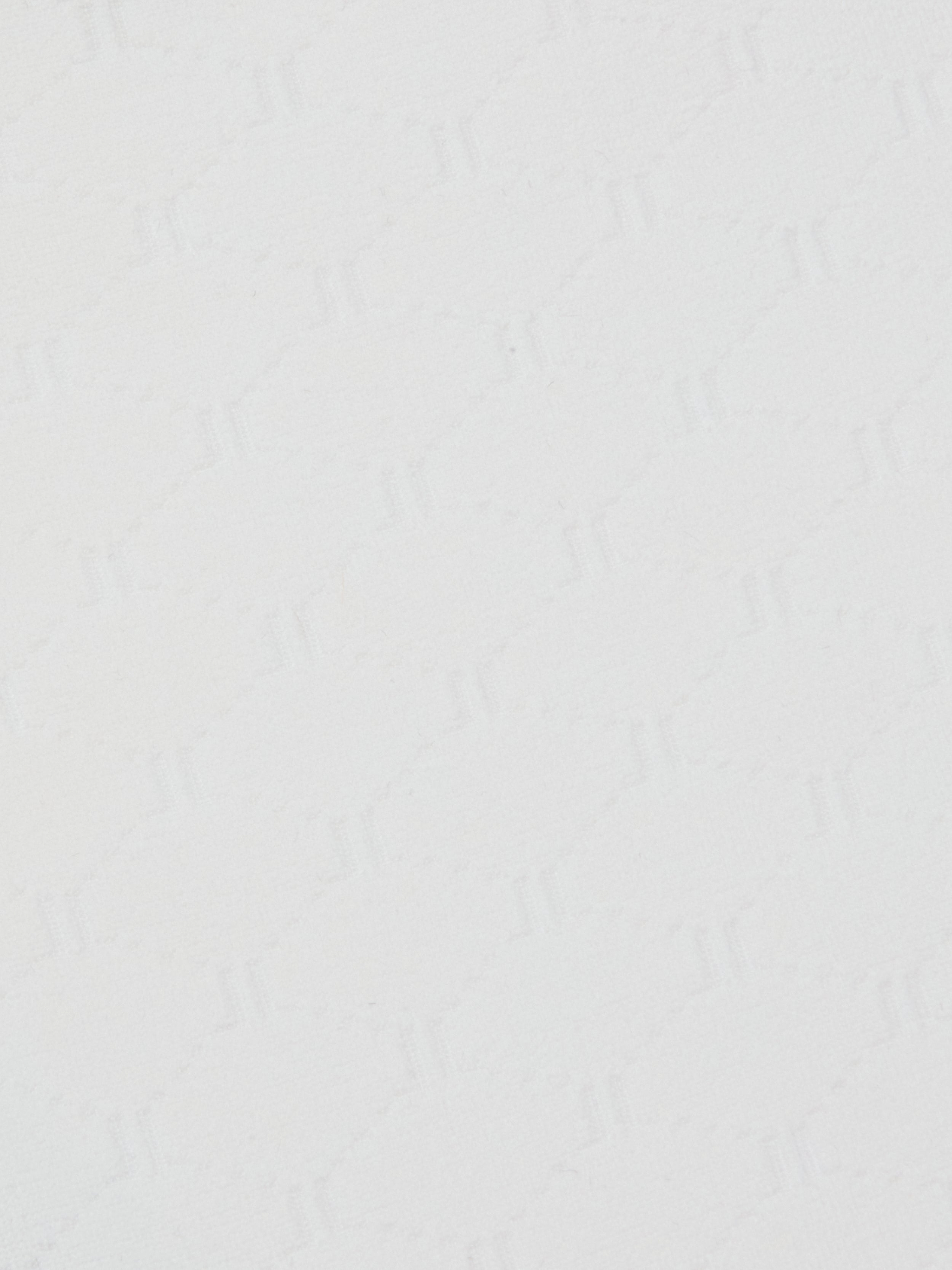 Close-up of the Annabelle Bikini Top’s white textured surface, featuring a subtle geometric pattern of repeating zigzag, triangle, and diamond shapes. The faint, monochromatic design adds gentle depth and visual interest to the otherwise simple background.