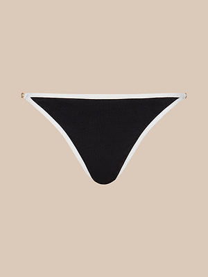 The Violet String Bikini Bottom, black with white trim and UPF 50 protection, is displayed flat on a beige background.
