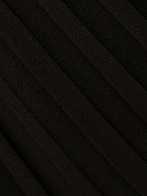 Close-up of the Adalynn Cover-Up Dress in black, featuring soft pleated fabric with diagonal, evenly spaced folds for a textured look—perfect for chic getaways or resort wear. Shadows enhance the depth and smoothness of the material.