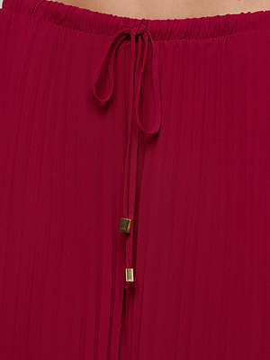Close-up of the Sharon Cover-Up Pant in red pleated chiffon, featuring an elastic waistband and drawstring tie with gold square metal tips.