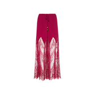 The Sharon Cover-Up Pant is a long, deep pink skirt featuring pleated chiffon at the top, sheer lace panels extending from mid-thigh to hem, a tie waist, and two decorative beads. It is displayed against a plain white background.