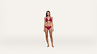 A woman stands barefoot against a plain white background, wearing a matching red bikini with a halter-style top and low-rise bottoms.