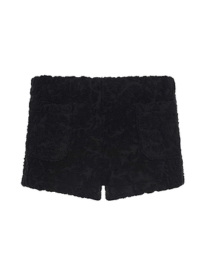 The Amiya Cover-Up Short is a pair of black terrycloth textured hot shorts with two front pockets, shown on a white background.