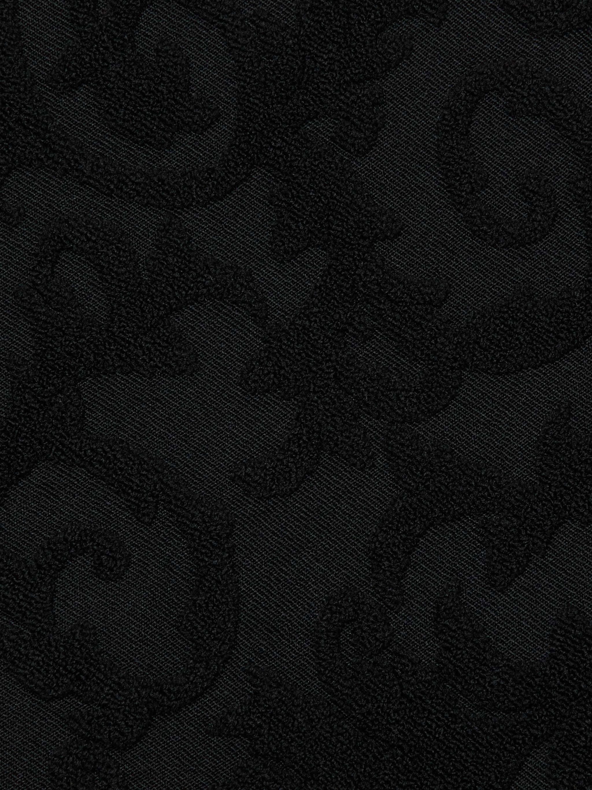 Black jacquard terry fabric with a subtle, raised paisley pattern. The intricate design is slightly shiny, offering texture and contrast against the matte background—perfect for a chic swim look like the Lexie Bikini Top.