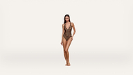 Woman standing barefoot, wearing a leopard print one-piece swimsuit, posing against a plain white background.