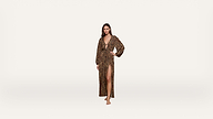 Woman stands barefoot wearing a long, leopard print dress with a deep V-neck, long sleeves, and a high slit up one leg, posing against a plain white background.