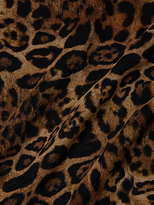 Close-up of the Klaire Cover-Up Skirt by L'AGENCE, showcasing versatile leopard print with irregular black spots and rosettes on brown and tan tones. The textured fabric is perfect for a stylish wrap skirt look.