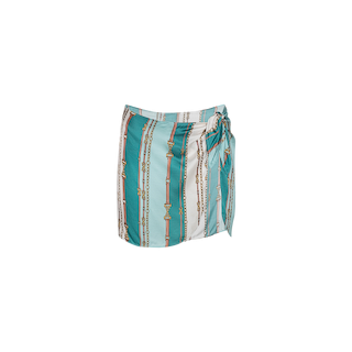 The Marceline Short Pareo is a satin skirt with teal, white, and gold vertical stripes in a striking belt-stripe print, featuring a side tie knot detail—perfect for pairing with your coordinating swimsuit.